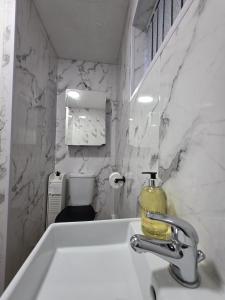 a bathroom with a sink with a soap dispenser on it at Cozy Birmingham city center home with free parking in Birmingham