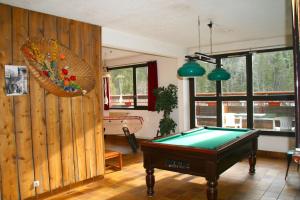 a living room with a pool table in it at Village vacances du Haut-Bréda aux 7 Laux in La Ferrière