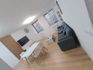 a living room with a couch and a table and chairs at APPART' nasaline in Dieuze