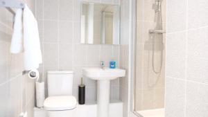 a bathroom with a toilet and a sink and a shower at 4 Bedroom 3 Bathroom House - Sleeps up to 8 - City Centre - Free Parking, Fast Wifi, Private Garden and Smart TV by Yoko Property in Milton Keynes