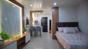 a bedroom with a bed and a dining room at Plumera Mactan near Airport in Bankal +24 photos