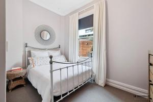 a bedroom with a bed and a window at Villa on Rattray in Dunedin
