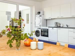 a kitchen with a table with a vase of flowers at Apartment in Holiday park- free waterpark in Ulfborg +42 photos