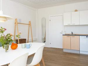 a white kitchen with a white table and chairs at Apartment in Holiday park- free waterpark in Ulfborg