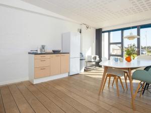 a kitchen with a table and a white refrigerator at Apartment in Holiday park- free waterpark in Ulfborg