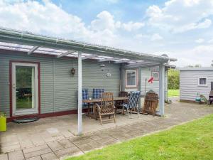 Eskebjergにある6 person holiday home in Eskebjerg-By Traumの家の前にテーブルと椅子が置かれたパティオ