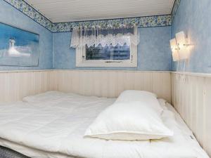 布洛克胡斯4 person holiday home in Blokhus-By Traum的带窗户的房间里有一张白色的床