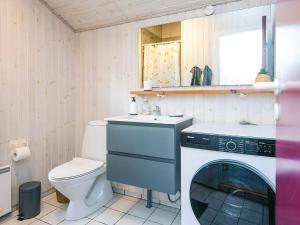 a bathroom with a washing machine and a toilet at Holiday Home with Spa & Sauna in Oksbøl +38 photos