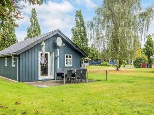 a blue shed with a table and chairs in a yard at 6 person holiday home in Hovborg in Hovborg