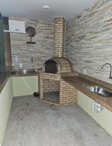 a brick oven in a kitchen with a sink at Golden lake apartamento com linda vista para piscina in Arraial do Cabo