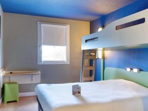 a bedroom with two bunk beds and a window at ibis budget La Roche Sur Yon Vendespace in Mouilleron-le-Captif +116 photos