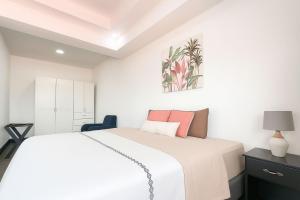 圣何塞XIN Bed&Breakfast的卧室配有带粉红色枕头的大型白色床 更多32张照片