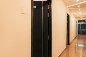 een hal met een zwarte lift in een gebouw bij Hotel O Happy Hotels in Vijayawāda
