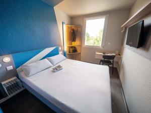 a bedroom with a white bed and a window at ibis budget Narbonne Est in Narbonne +54 photos
