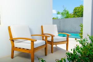two chairs sitting on a porch next to a pool at The Hidden Cottage in Welches Hill