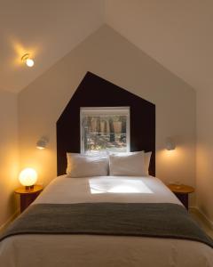 Una cama grande con cabecera negra y almohadas blancas. en Colorado Lodge, en Big Bear Lake