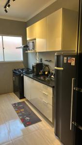 a kitchen with stainless steel appliances and a black refrigerator at Hospedagem de qualidade in Varginha +24 photos