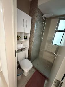 a bathroom with a toilet and a glass shower at Place Beira Mar in Recife