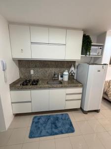 a kitchen with white cabinets and a white refrigerator at Place Beira Mar in Recife +4 photos