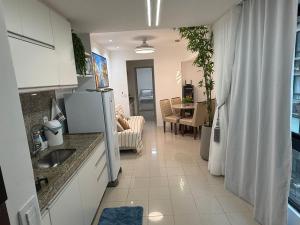 a kitchen with a refrigerator and a living room at Place Beira Mar in Recife