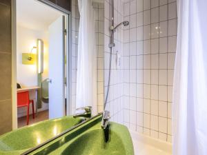 a green bath tub in a bathroom with a shower at ibis budget Limoges Centre Gare in Limoges +47 photos