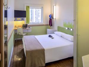 a hotel room with a bed and a desk at ibis budget Belo Horizonte Minascentro in Belo Horizonte