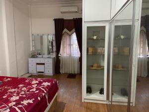 a bedroom with a bed and a dresser and a mirror at Nisa Homestay in Hagu