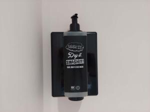 a black bottle of sunscreen on a wall at Ibis Budget Bayeux in Bayeux +30 photos