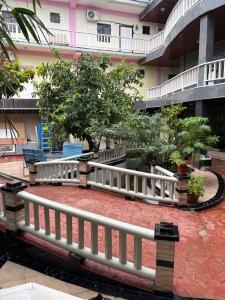 une clôture blanche devant un bâtiment arboré dans l'établissement China Town Hotel, à Caye Caulker