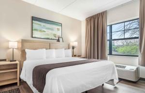 a hotel room with a large bed and a window at Extended Stay America Suites - Long Island - Melville in Melville