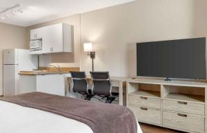 a hotel room with a bed and a desk with a flat screen tv at Extended Stay America Suites - San Diego - Carlsbad Village by the Sea in Carlsbad
