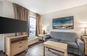 a living room with a couch and a flat screen tv at Extended Stay America Suites - San Diego - Carlsbad Village by the Sea in Carlsbad