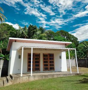 a small white house with a blue sky at La Minimalista in Bagac