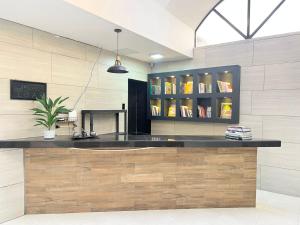 a kitchen with a counter with a book shelf at XIN Bed&Breakfast in San José