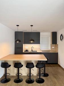 a kitchen with a wooden counter with stools around it at Apartment Mani in Koper