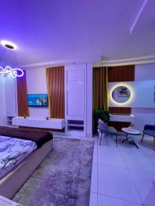 a bedroom with a bed and a couch and a table at Emiola mews apartments in Lekki