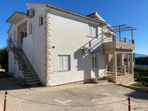 a white house with stairs on the side of it at Apartments by the sea Rogac, Solta - 21346 in Rogač