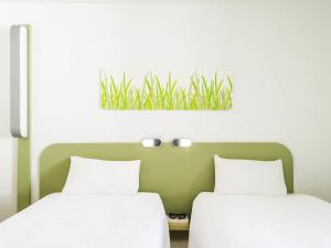Ένα ή περισσότερα κρεβάτια σε δωμάτιο στο ibis budget Metz Sud