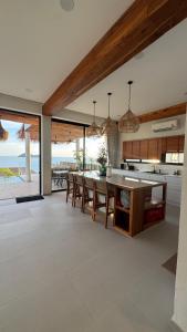 eine offene Küche und ein Esszimmer mit Tisch und Stühlen in der Unterkunft Sitaya Beachfront Villas, Koh Phangan in Ko Phangan
