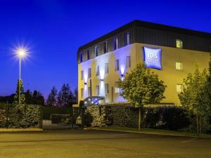Un edificio con un cartel azul al costado. en ibis budget Amboise, en Amboise