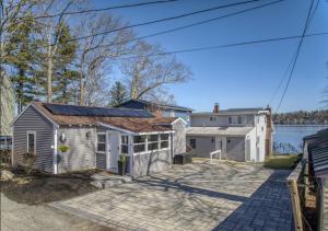 a house with a solar roof on a driveway at 2-bed rm house on the lake in Merrimac