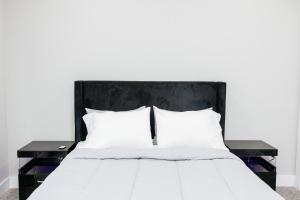a bed with white sheets and two black tables at Luxury 3BR Getaway Near Downtown - Med Center - NRG - Enjoy Smart TVs - Fast WiFi - Private Backyard in Houston
