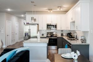 a kitchen with white cabinets and a counter top at Luxury 3BR Getaway Near Downtown - Med Center - NRG - Enjoy Smart TVs - Fast WiFi - Private Backyard in Houston