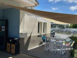 a patio with a table and chairs and an umbrella at Hôtel Ibis Budget Nantes Nord St Herblain in Saint-Herblain