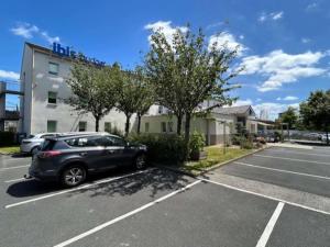 a car parked in a parking lot in front of a building at Hôtel Ibis Budget Nantes Nord St Herblain in Saint-Herblain