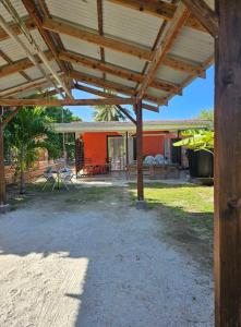 a patio with a wooden roof and a house at Rangiroa Maison entière privée 1 chambre 4 personnes climatisée in Ataiti