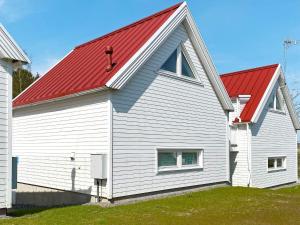 a white house with a red roof at 4 star holiday home in Åkersberga in Åkersberga