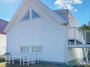 a white house with a table and chairs on it at 4 star holiday home in Åkersberga in Åkersberga +16 photos