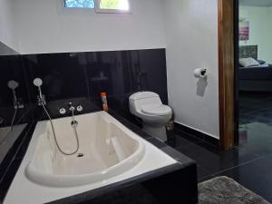 Un baño con bañera y WC. en Taw K'a Cabañas, 