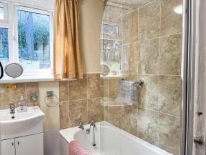 a bathroom with a bath tub and a sink at Eastry Cottage in Castleton